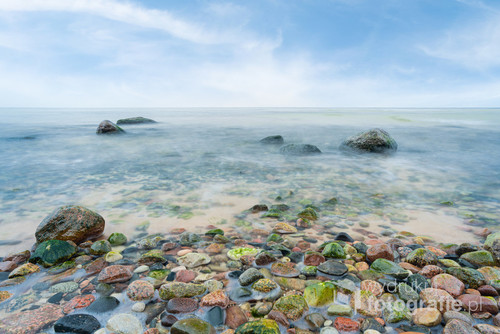 A view of the rocky beach in Miedzyzdroje. Baltic sea. Stones into the water. Blurry effect with long exposure.