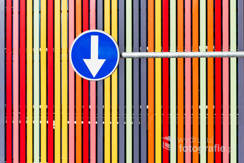 Road-sign of left turn order on multicolored strips background 