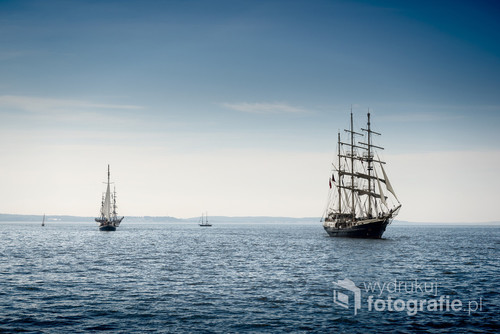 Tall ship sailing on blue water.