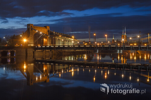 Zabytkowy most wiszący nad rzeką Odrą wieczorową porą